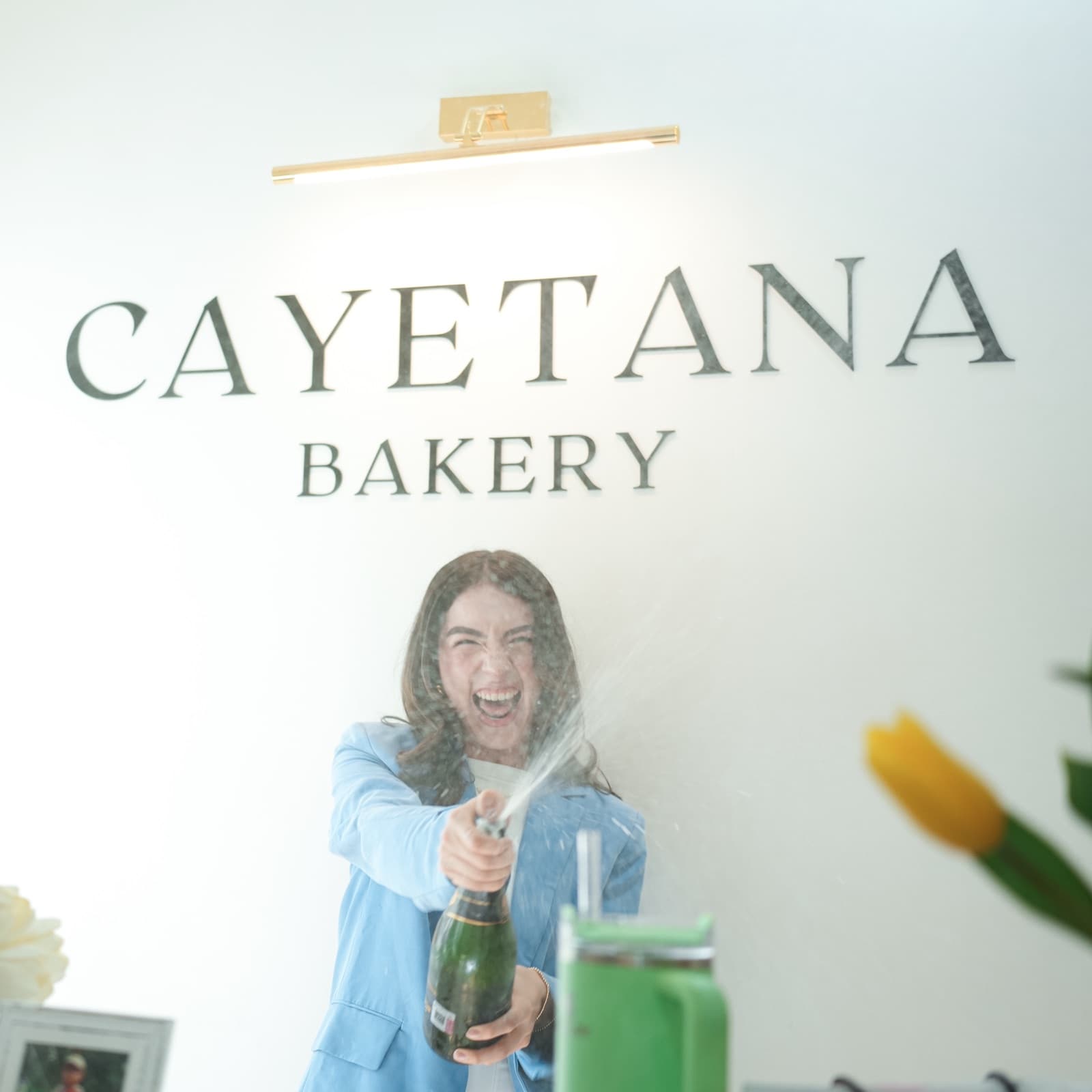 Cinthia Martínez descorchando champán el día de la inauguración de Cayetana Bakery